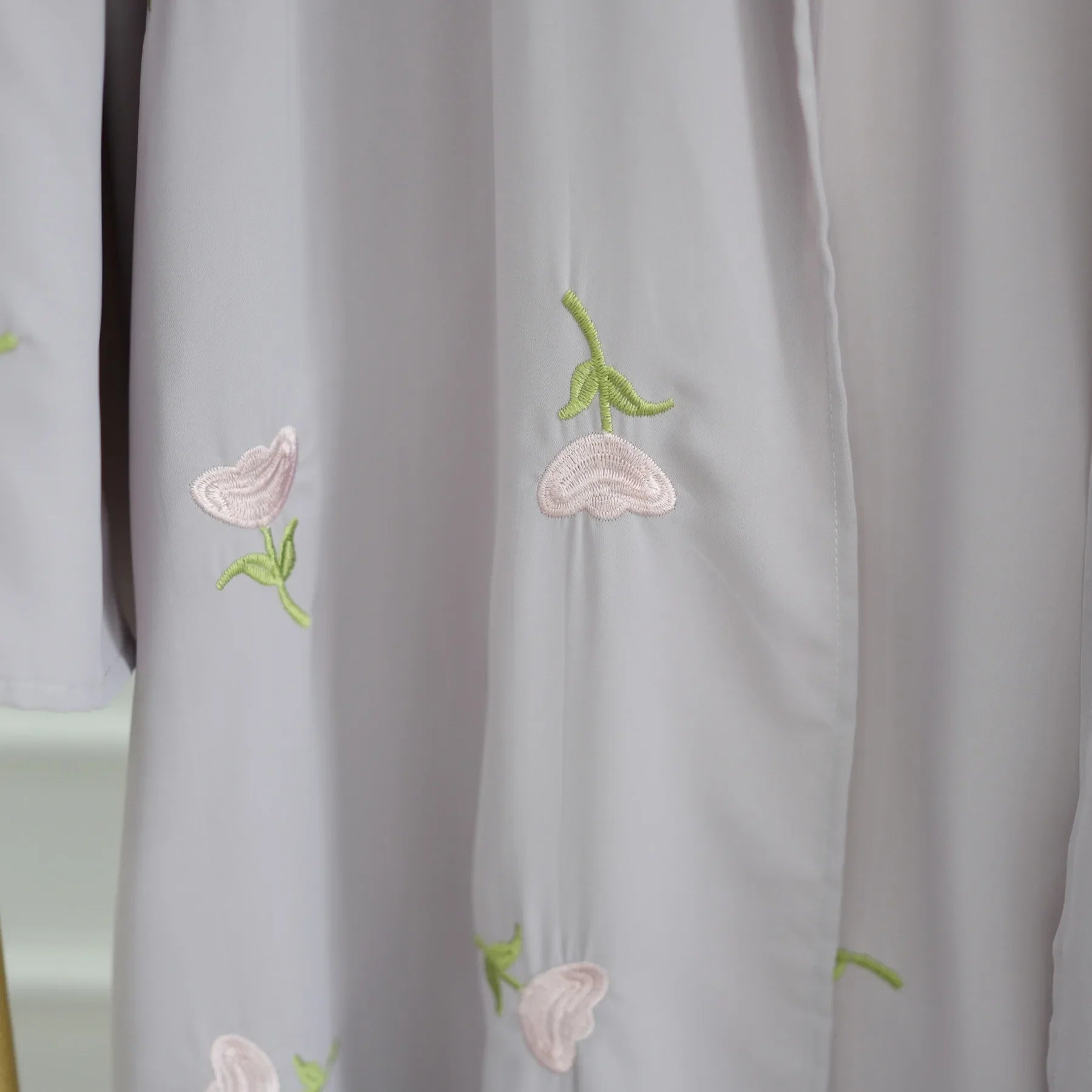 Close-up of the floral embroidery on The Maison Brodee in gray